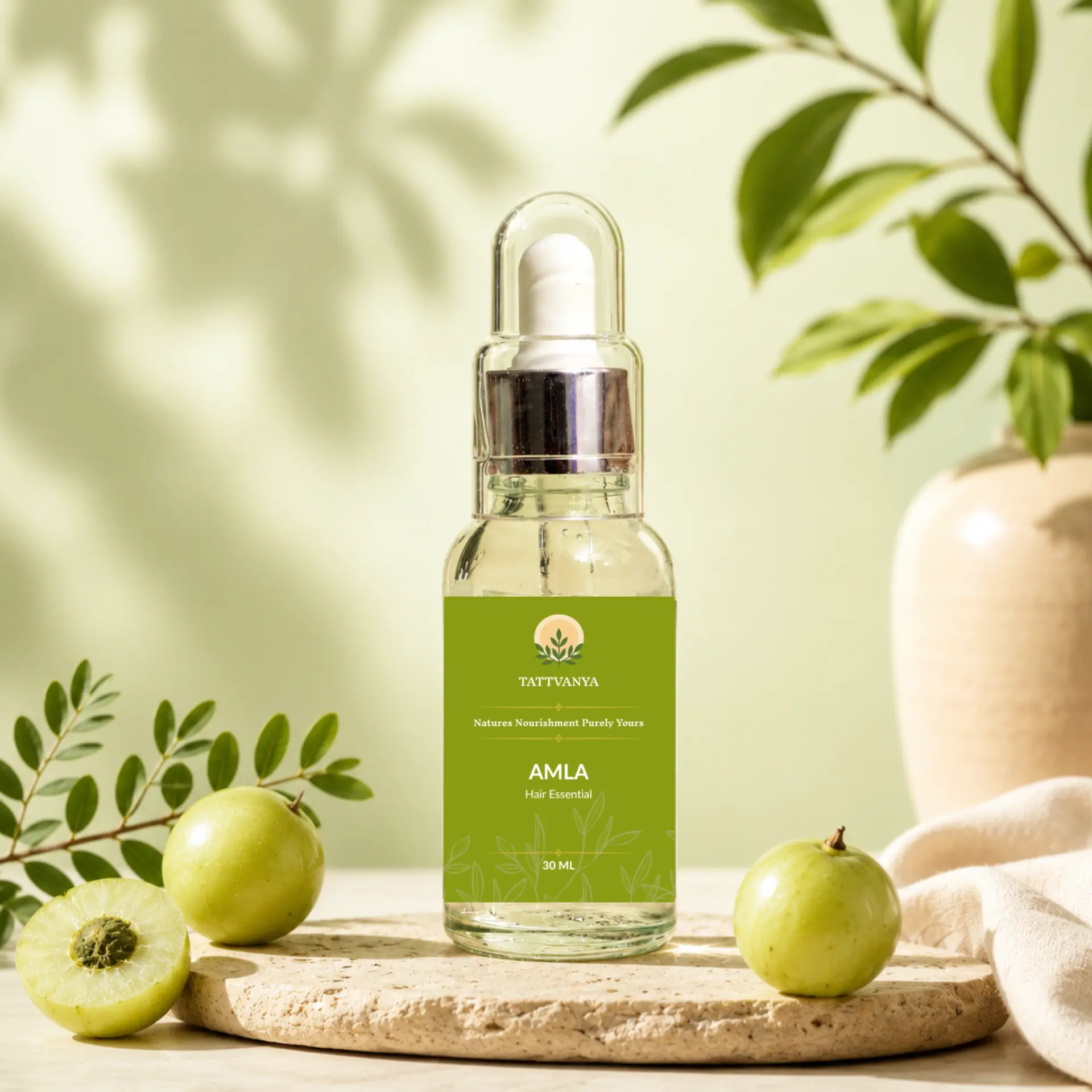 Tattvanya amla hair oil with fresh amla fruit on a stone tray